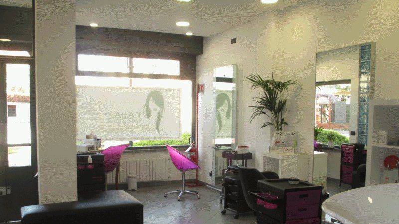 Le postazioni del salone, con poltrone fucsia e grandi specchi